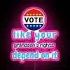 Neon sign with colorful letters reading 'Vote like your grandson's rights depend on it'
