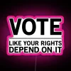 Vibrant neon sign with bold, colorful letters reading 'Vote Like Your Rights Depend On It'