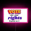 Neon sign with colorful letters spelling out 'Vote Like Your Rights Depend On It'