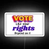 Neon sign reading 'Vote like your rights depend on it' in bold, colorful letters.