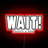 Neon sign with colorful letters reading 'Wait, there's a bird' in a playful style.