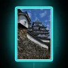 Walkway to Himeji Castle with RGB neon lights at night, illuminated in blue hue.