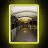 Neon-lit walkway with vibrant yellow signage at night