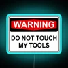 Warning sign with neon blue letters saying 'Do Not Touch My Tools'