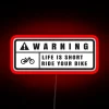 Neon warning sign with bold red letters on a dark background.