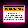 Neon warning sign with bold, cursive letters announcing a person's tendency to have spontaneous and exuberant sewing frenz...