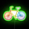 Vibrant neon rainbow bicycle sign depicted in watercolor style with green accents.