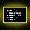Neon sign with colorful, glowing letters reading "What a horrible night to have a curse" in a distressed, retro style.