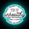 Neon sign with colorful letters reading 'What Doesn't Kill You Disappoints Me'