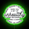 A colorful, neon-lit sign reading 'What Doesn't Kill You Disappoints Me'