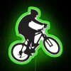 Mountain biker performing a wheelie on a neon-lit bike.