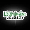 Wilmington University's neon sign reflecting off a wet pavement at night
