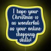 Colorful neon sign with funny Christmas sayings in bold, cursive font against a yellow background.