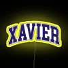Neon sign with a curved font reading Xavier College in bright yellow letters.