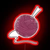 Vibrant red yarn ball against a neon-lit background with colorful RGB hues.