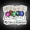 A colorful, organized collection of yarns with a neon sign reading 'RGB' in white.