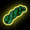A skein of yarn in a vibrant, neon green color against a yellow background.