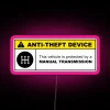 Yellow anti-theft device warning sign on a 5-speed manual transmission with neon RGB lights.