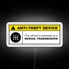 Yellow anti-theft device warning sign with neon lighting on a 5-speed manual transmission vehicle.