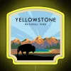 Yellowstone National Park entrance with neon sign at dusk.