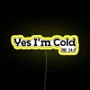 Neon sign reading "Yes, I'm cold" with bright yellow color scheme.