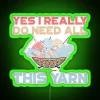A person surrounded by yarn with an LED neon sign reading "Yes, I really do need all this yarn". Alt Text: "Woman surround...