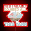 A bundle of colorful yarn with an LED sign that reads "Yes, I really do need all this.