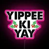 Neon sign with bright pink letters spelling out "Yippee Ki Yay" in a stylized, 8-bit-inspired font.