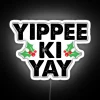 Neon sign reading Yippee-Ki-Yay in bold, colorful letters against a white background.