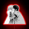 Close-up of Yona and Hak standing in front of a colorful neon sign at night.