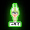 Yoo Jae Suk on the set of Running Man with an RGB neon sign background in a green toned photo.