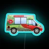 Red neon sign advertising Yorkshire Tea on the side of a van in a vibrant urban setting.