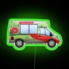 Yorkshire Tea van with bright red and green neon sign illuminated at night.