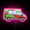 A brightly lit, red neon sign reading "Yorkshire Tea" in a classic van design at night.