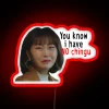 Young adult holding a neon sign with humorous message