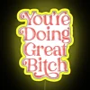 Neon pink and red sign with encouraging phrase in bold, futuristic font.
