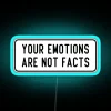 Neon sign reading "Your emotions are not facts" in blue letters.