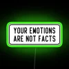 Neon sign with colorful letters saying "Your emotions are not facts" in a futuristic style.