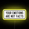 Neon sign with bold typography declaring that emotions are not facts, set against a yellow background.