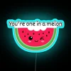 Neon melon sign in blue and green hues, illuminated at night.