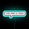 Neon sign with bold, cursive font reading 'Your waifu is trash'