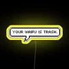 Neon sign with bold, colorful letters reading 'Your Waifu is Trash'