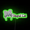 Cat sitting in front of a colorful neon sign.