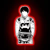 Formula 1 driver Yuki Tsunoda with a neon-lit RGB sign in red.