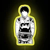 Yuki Tsunoda standing in front of an RGB neon sign with his name, wearing a Formula 1 suit.