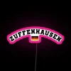Porsche's Zuffenhausen factory illuminated at night with neon lights and a pink hue