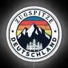 Mountain peak with neon sign in Germany, Zugspitze landscape at sunset.